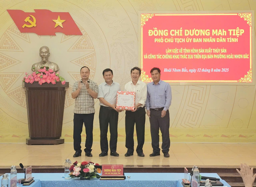 Phó Chủ tịch UBND tỉnh Dương Mah Tiệp (bìa trái) tặng quà cho phường Hoài Nhơn Bắc. Ảnh: Đức Hải 12-7.jpg