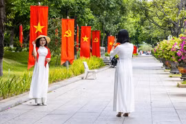 Người dân, du khách tranh thủ check in với cờ đỏ sao vàng trên đường Nguyễn Tất Thành.