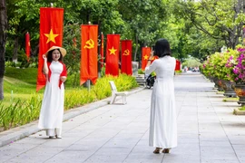Người dân, du khách tranh thủ check in với cờ đỏ sao vàng trên đường Nguyễn Tất Thành.