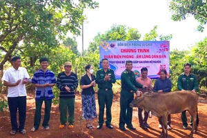 Cán bộ Đồn Biên phòng Ia Chía và đại diện chính quyền địa phương trao bò giống cho hộ ông Kih.