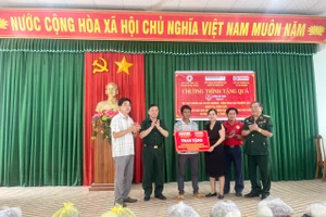 Đại diện nhà tài trợ trao tặng kinh phí xây dựng nhà tình thương cho gia đình ông Rcom Bao (thứ 3 từ trái sang, tổ dân phố 7, thị trấn Phú Thiện). Ảnh: Vũ Chi