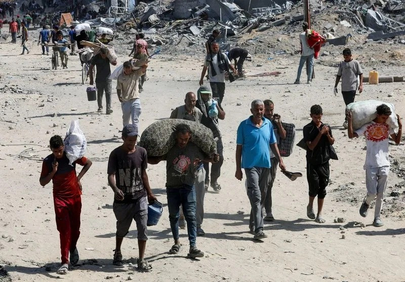 Người dân trở về Gaza sau khi Israel thông báo đã hoàn tất rút quân giai đoạn 1. Ảnh: Reuters b630ad8d99306b5ebf3239d99e176440.jpg