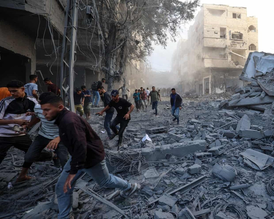 Người dân chạy trốn khi Israel không kích một tòa nhà ở trại Bureij, trung tâm Gaza vào ngày 19-10. Ảnh: Eyad Baba/AFP/Getty Images 3913.jpg