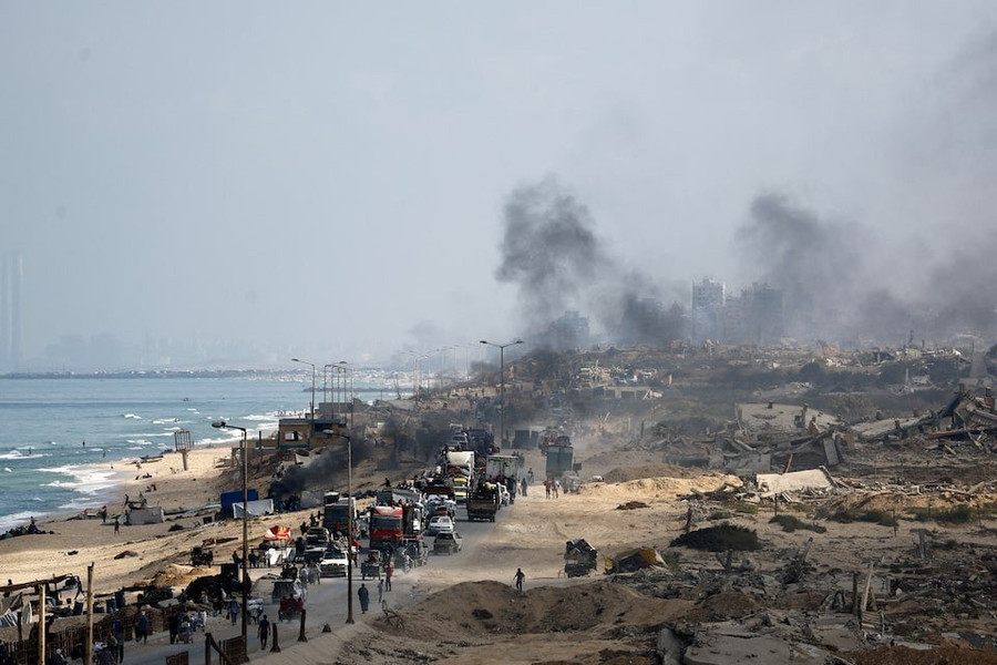 Dòng người rời khỏi Thành phố Gaza, phía sau là khói bốc lên từ các cuộc không kích của Quân đội Israel. Ảnh: Reuters ipvhzq4xwzocziyuqygm44wioy.jpg