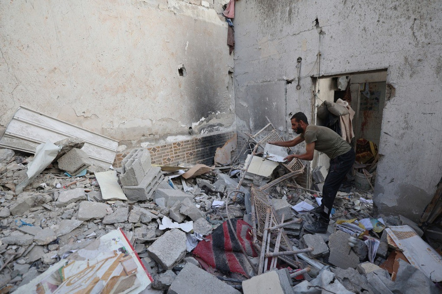 Người dân Palestine đứng trong đống đổ nát do đòn không kích của Israel nhằm vào Dải Gaza. Ảnh: AFP afp-20251020-79d42zr-v1-highre-1.jpg