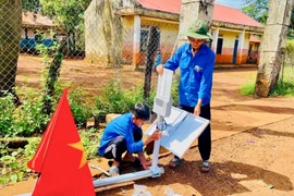 Đoàn viên, thanh niên lắp đặt trụ điện năng lượng trời để tặng người dân. Ảnh: ĐVCC