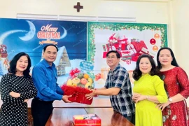 Anh Đỗ Đức Thanh (thứ 2 từ trái sang) tặng quà chúc mừng Câu phó Võ Cường (thứ 3 từ phải sang) nhân dịp Giáng sinh. Ảnh: ĐVCC