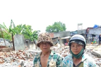 Vợ chồng bà Mai xót xa nhìn căn nhà cùng nhiều tài sản bị thiêu rụi. Ảnh: Hữu Thành