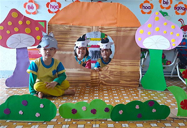 Các bé thích thú học tập với sa bàn kể chuyện mà cô Nhài làm. Ảnh: M.T