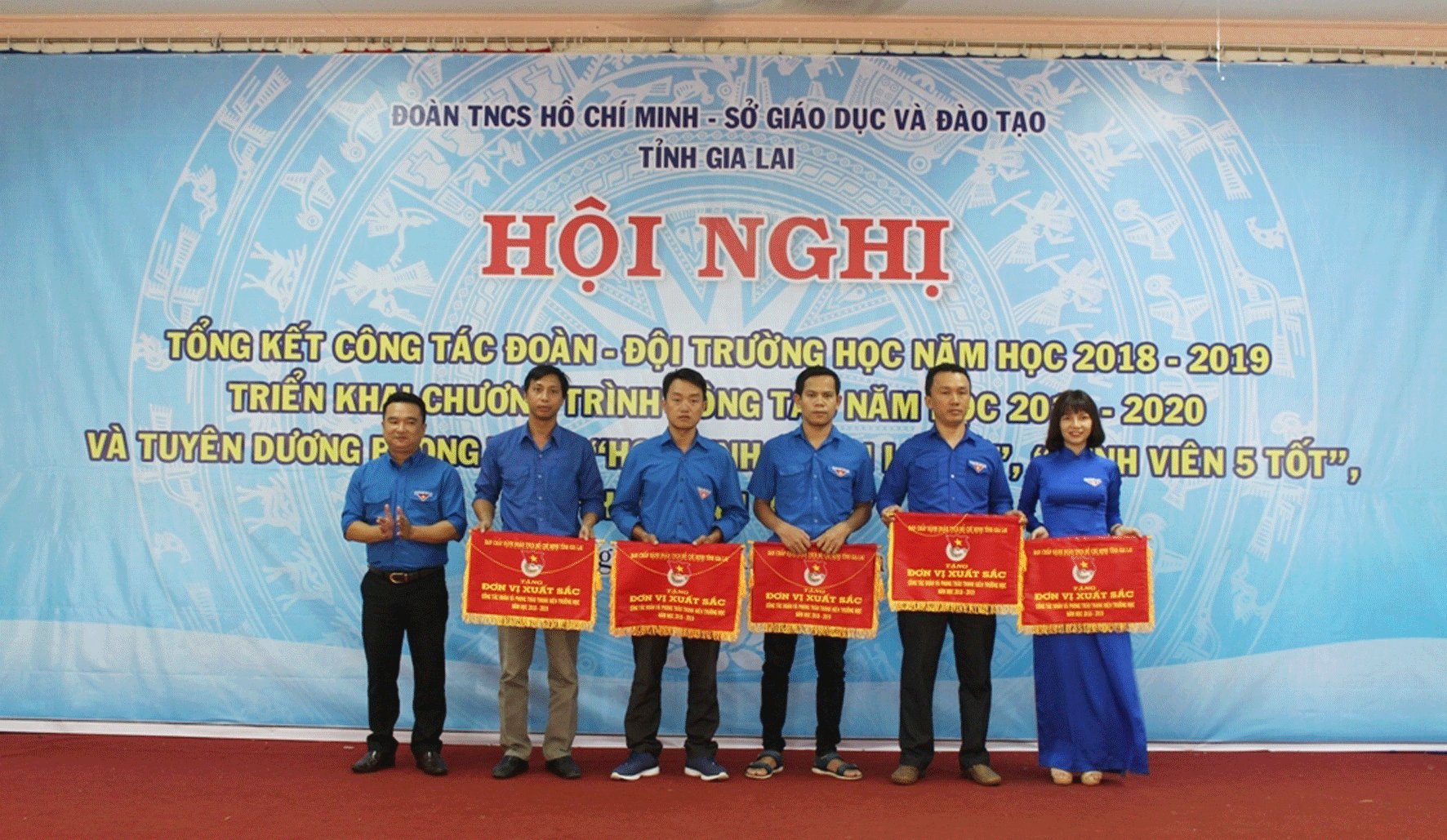 Chị Hoàng Thị Thanh Tú (bìa phải) đại diện Trường THPT Mạc Đĩnh Chi nhận cờ thi đua đơn vị xuất sắc của Tỉnh Đoàn vì có thành tích xuất sắc trong công tác Đoàn và phong trào thanh niên trường học. Ảnh: P.L