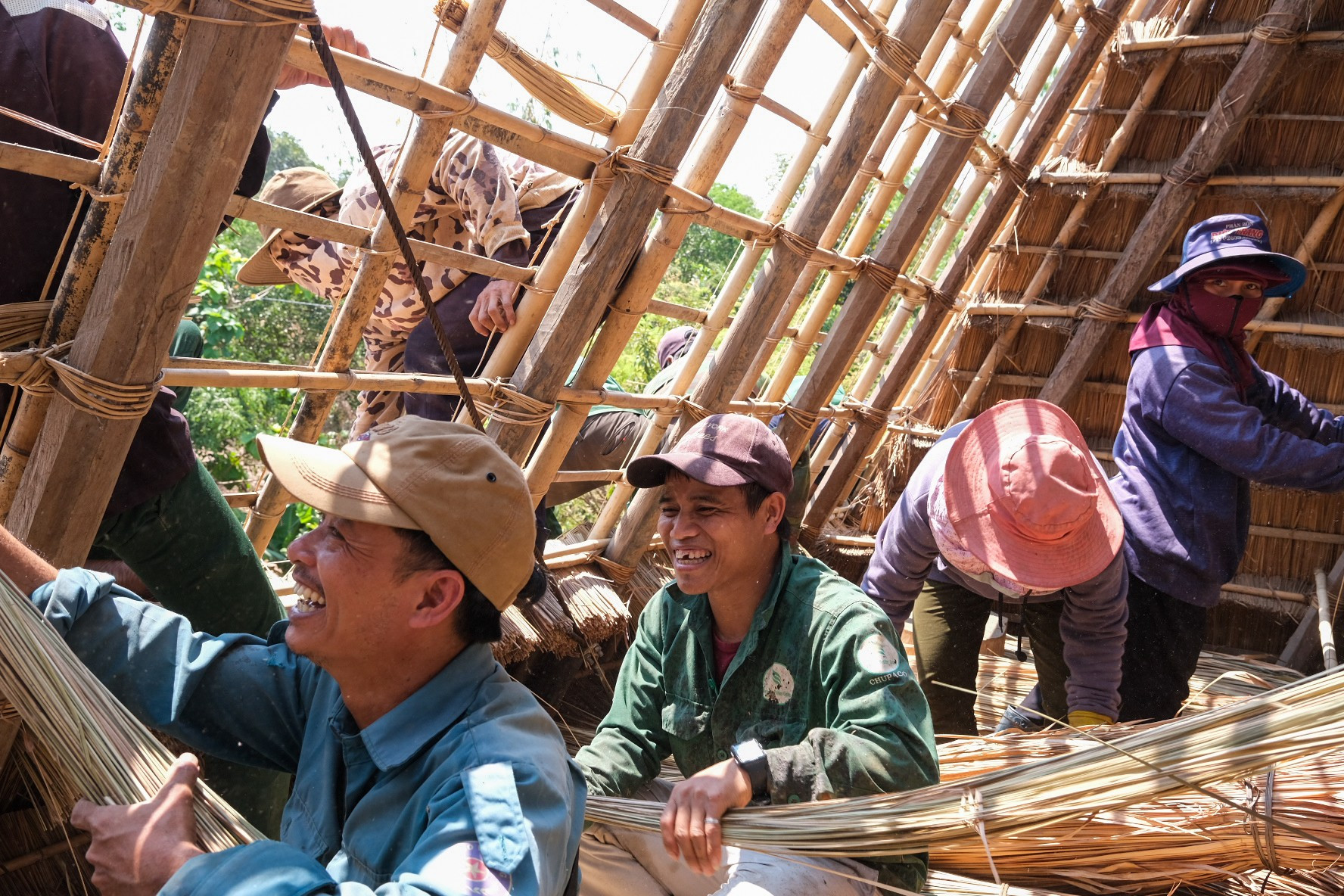 Những bó tranh được đưa từ bên trong nhà rông để lợp mái. Ảnh: Hoàng Ngọc dua-tranh-tu-en-trong-dua-tranh-ra-ben-ngoai-de-lop-mai.jpg