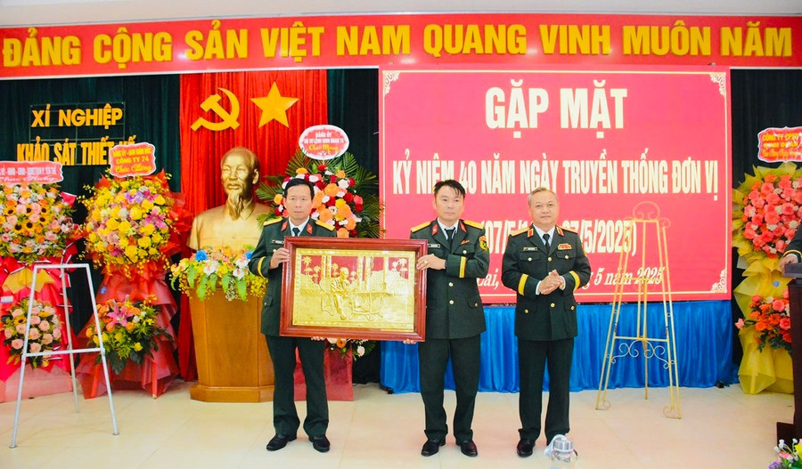 Thiếu tướng Hoàng Văn Sỹ-Tư lệnh Binh đoàn 15 (bìa phải) trao quà cho Xí nghiệp Khảo sát thiết kế. Ảnh: Anh Sơn z6575786116660-dd39d78c00912c5aa1850f558a33c103.jpg