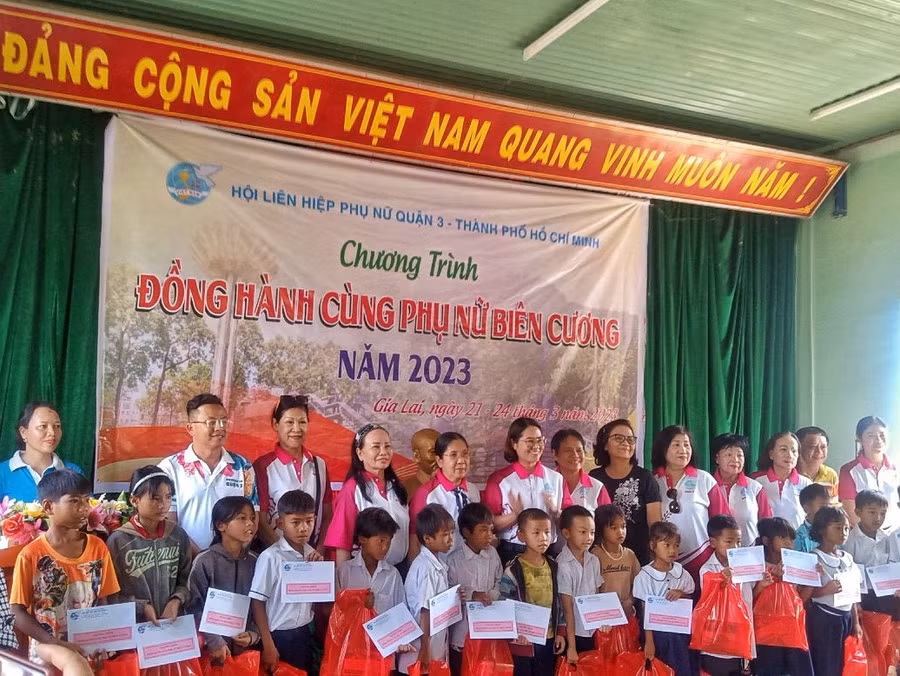 Đoàn công tác tặng học bổng cho trẻ em nghèo hiếu học. Ảnh: Minh Châu