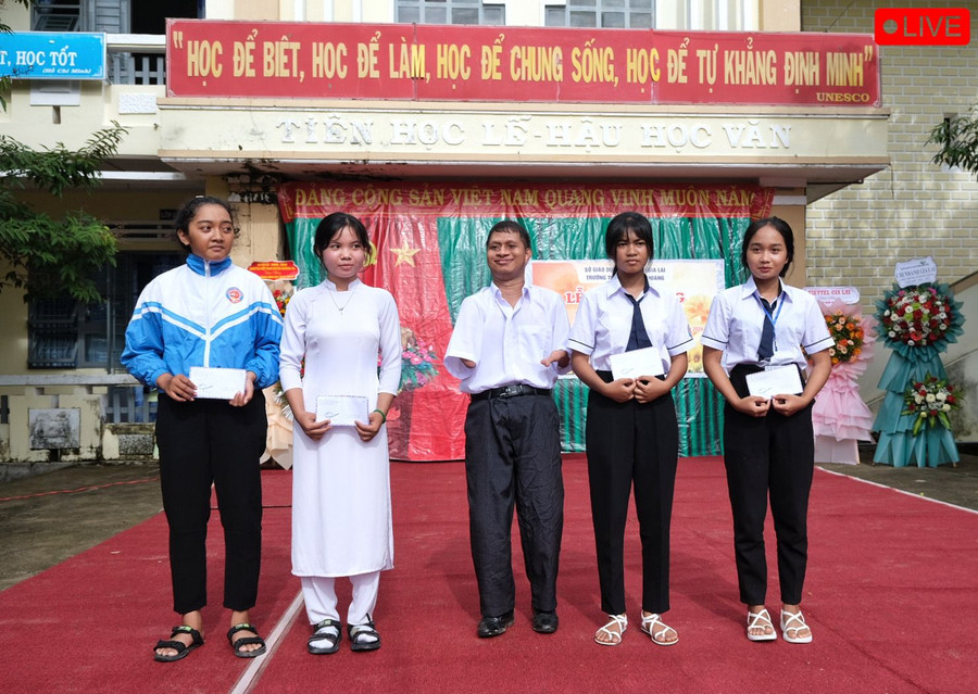 Anh Nay Djruêng (giữa)-cựu học sinh của trường THPT Đinh Tiên Hoàng trao học bổng "Đi qua mùa rẫy" cho học sinh hiếu học. Ảnh: HOÀNG NGỌC Anh Nay Djruêng (giữa)-cựu học sinh của trường THPT Đinh Tiên Hoàng trao học bổng "Đi qua mùa rẫy" cho học sinh hiếu học. Ảnh: HOÀNG NGỌC