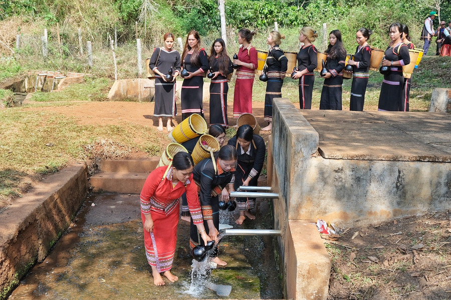Phụ nữ trong làng thực hiện nghi thức lấy nước vào bầu khô với mong muốn nguồn nước luôn dồi dào, tuôn chảy. Ảnh: Hoàng Ngọc Phụ nữ trong làng thực hiện nghi thức lấy nước vào bầu khô với mong muốn nguồn nước luôn dồi dào, tuôn chảy. Ảnh: Hoàng Ngọc