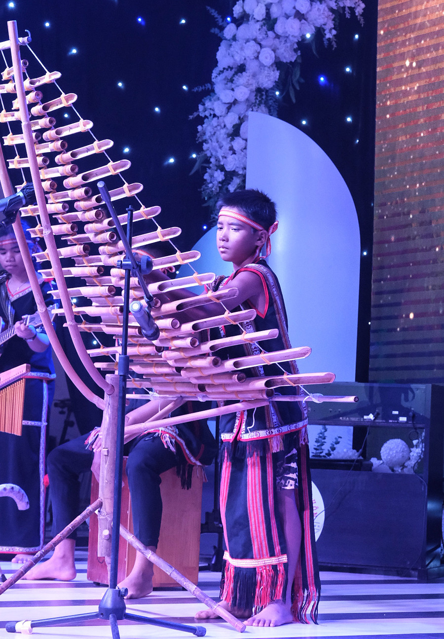 Kpă Jun được nhận nuôi từ nhỏ, em tự tin thể hiện liên khúc Anh hùng Núp, Bụi phấn, Mừng chiến thắng trên cây đàn t&apos;rưng. Ảnh: MINH CHÂU