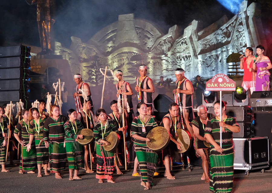 Người M&apos;nông Sre của Đak Nông nổi bật trong sắc thổ cẩm xanh đen và đánh chiêng bằng tay không. Ảnh: Hoàng Ngọc