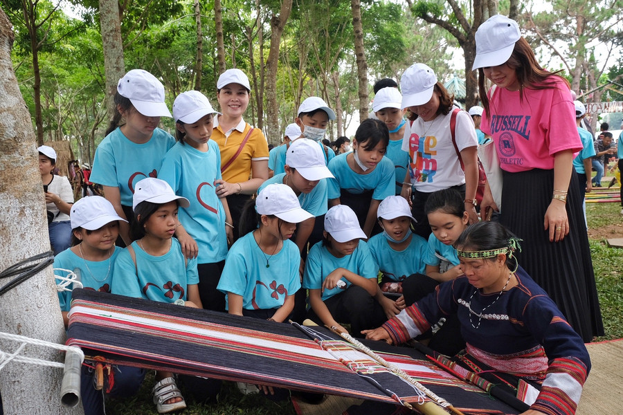 Học sinh Trường Tiểu học Kim Đồng (huyện Ia Grai) tìm hiểu nghề dệt truyền thống cùng nữ nghệ nhân Bahnar. Ảnh: Hoàng Ngọc Học sinh Trường Tiểu học Kim Đồng (huyện Ia Grai) tìm hiểu nghề dệt truyền thống cùng nữ nghệ nhân Bahnar. Ảnh: Hoàng Ngọc