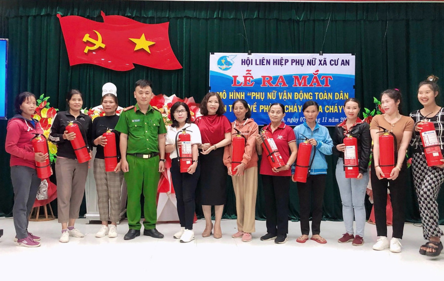 Tặng bình chữa cháy cho hội viên phụ nữ tham gia mô hình. Ảnh: Minh Châu