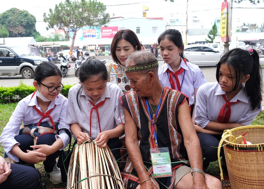 Các em học sinh được nghệ nhân hướng dẫn đan lát. Ảnh: Hoàng Ngọc Các em học sinh được nghệ nhân hướng dẫn đan lát. Ảnh: Hoàng Ngọc