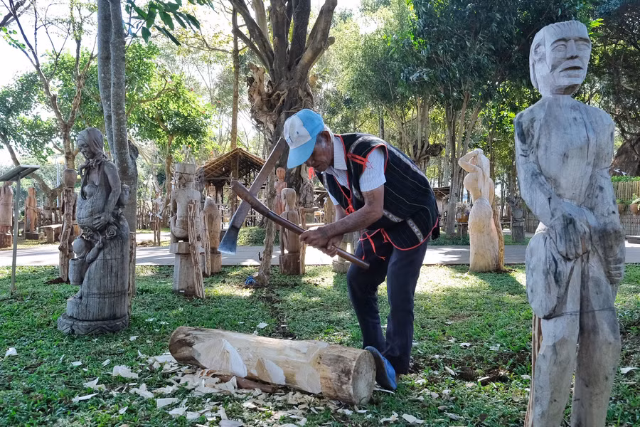 Nghệ nhân đẽo tượng trong khu vườn tượng. Ảnh: Hoàng Ngọc