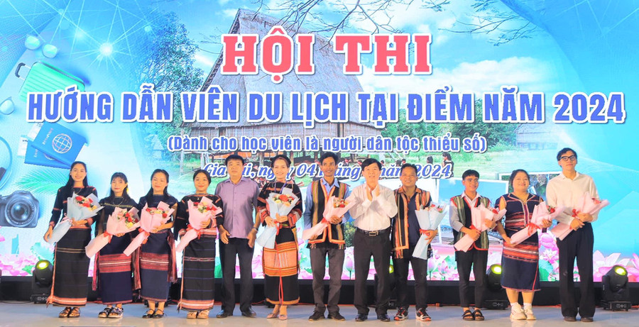 Ban tổ chức tặng hoa cho các thí sinh tham gia hội thi hướng dẫn viên du lịch tại điểm dành cho người dân tộc thiểu số. Ảnh: ĐVCC