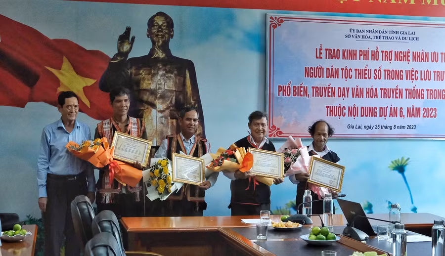 Phó giám đốc Sở Văn hóa-Thể thao và Du lịch Nguyễn Đức Hoàng (bìa trái) trao kinh phí hỗ trợ cho các nghệ nhân. Ảnh: Hoàng Ngọc