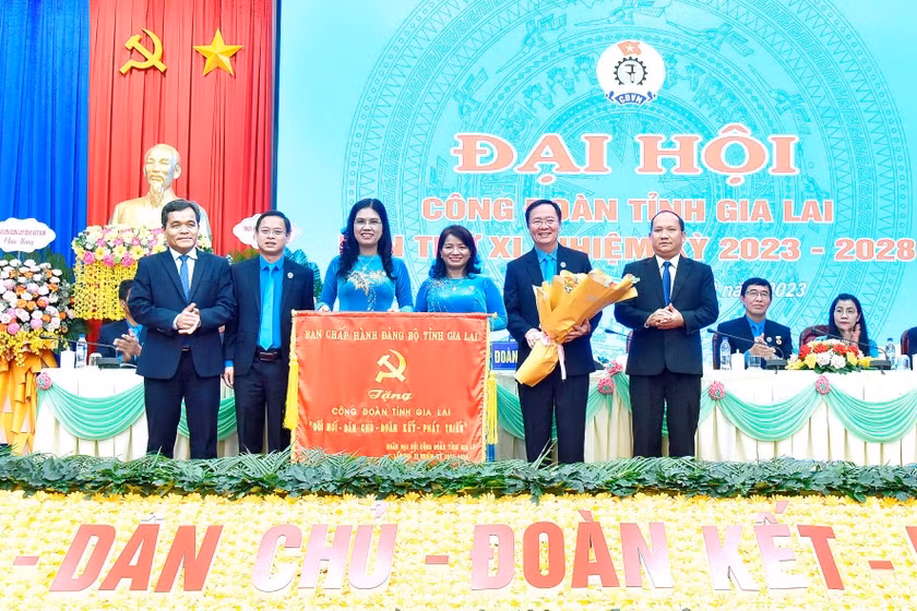 Ủy viên Ban Chấp hành Trung ương Đảng, Bí thư Tỉnh ủy, Chủ tịch HĐND tỉnh Hồ Văn Niên (bìa trái) và Phó Bí thư Tỉnh ủy Rah Lan Chung (bìa phải) trao tặng bức trướng của Ban Chấp hành Đảng bộ tỉnh cho Công đoàn tỉnh Gia Lai với nội dung: “Đổi mới-Dân chủ-Đoàn kết-Phát triển”. Ảnh: Đức Thụy