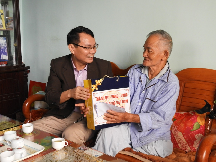 Bí thư Thành ủy Trịnh Duy Thuân (bên trái) thăm, tặng quà ông Lê Tranh là thương binh hạng 1/4 ở xã Trà Đa. Ảnh: Thanh Nhật