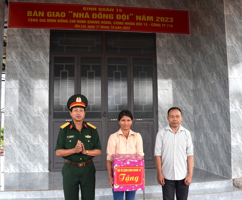 Thừa ủy quyền của Bộ tư lệnh Binh đoàn 15, Đại tá Nguyễn Phúc Khính (bìa trái)-Giám đốc Công ty 715 trao quà của Binh Đoàn 15 cho gia đình công nhân Đinh Quang Hùng. Ảnh: Đinh Yến