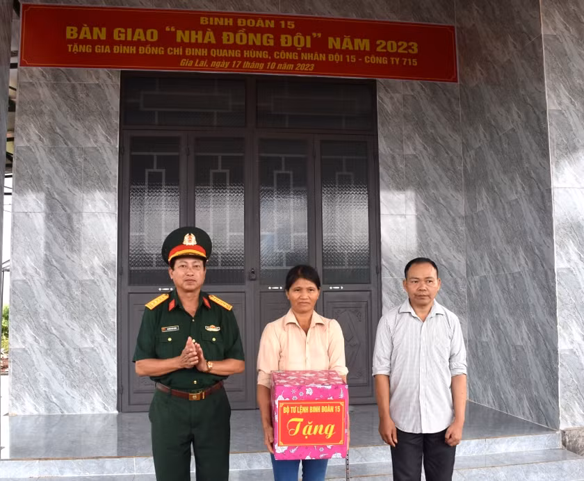 Thừa ủy quyền của Bộ tư lệnh Binh đoàn 15, Đại tá Nguyễn Phúc Khính (bìa trái)-Giám đốc Công ty 715 trao quà của Binh Đoàn 15 cho gia đình công nhân Đinh Quang Hùng. Ảnh: Đinh Yến