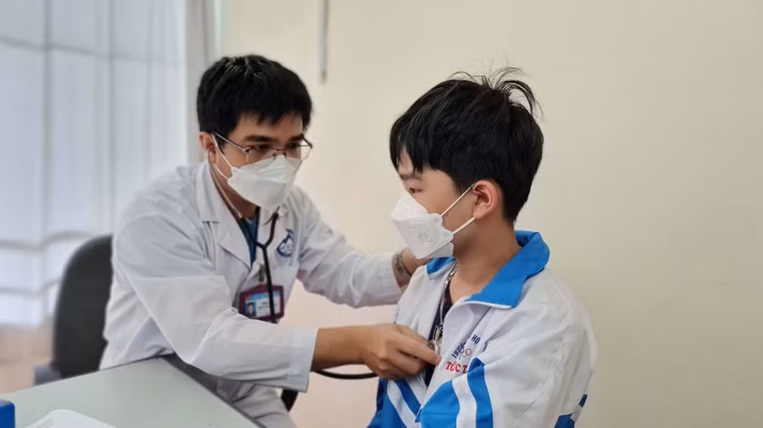 Nhân viên y tế kiểm tra sức khỏe cho trẻ trước khi tiêm vắc xin phòng Covid-19 tại Trung tâm Y tế TP. Pleiku. Ảnh: Bá Bính