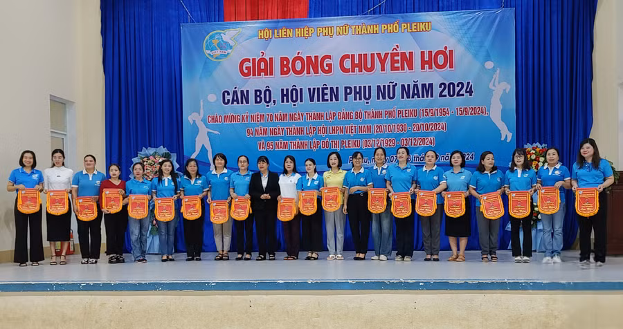Ban tổ chức trao cờ lưu niệm cho đại diện các Hội Liên hiệp phụ nữ cơ sở. Ảnh: Bá Bính