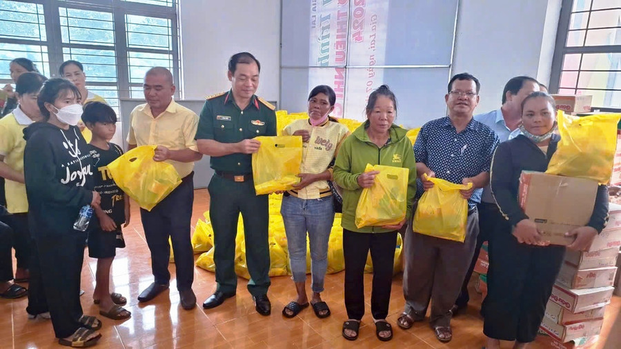 Đại diện Ban Chỉ huy Quân sự huyện Đức Cơ và Hội LHPN Phường 6 (Quận 8, TP. Hồ Chí Minh) tặng quà các gia đình có hoàn cảnh khó khăn xã Ia Lang. Ảnh: Kim Hồng