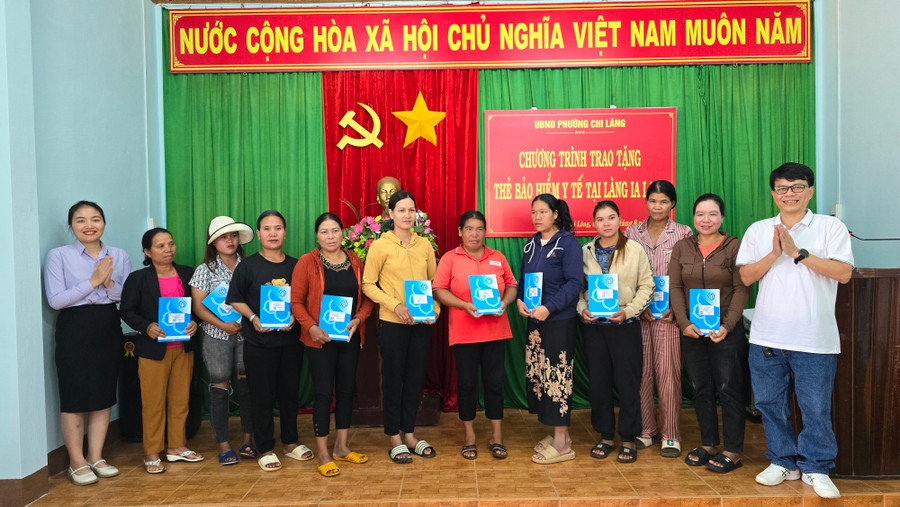Đại diện BHXH tỉnh cùng lãnh đạo UBND phường Chi Lăng và đại diện Công ty TNHH Xuất nhập khẩu Hoa Trang đã trao tặng 100 thẻ BHYT cho người dân tộc thiểu số có hoàn cảnh khó khăn tại làng Ia Lang. Ảnh: Bá Bính