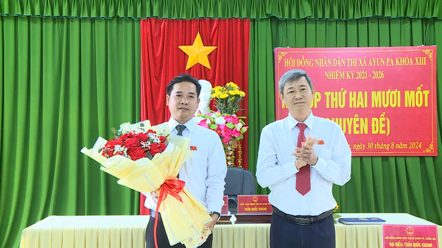 Ông Trần Quốc Khánh-Tỉnh ủy viên, Bí thư Thị ủy, Chủ tịch HĐND thị xã Ayun Pa tặng hoa chúc mừng tân Phó Chủ tịch HĐND thị xã khóa XIII Nguyễn Chí Cường (bên trái). Ảnh: Nguyễn Sang