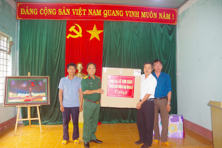 Dịp này, Đại tá Lê Kim Giàu tặng phần quà cho cán bộ và nhân dân thôn Cửa Khẩu. Ảnh: Thanh Tuyền