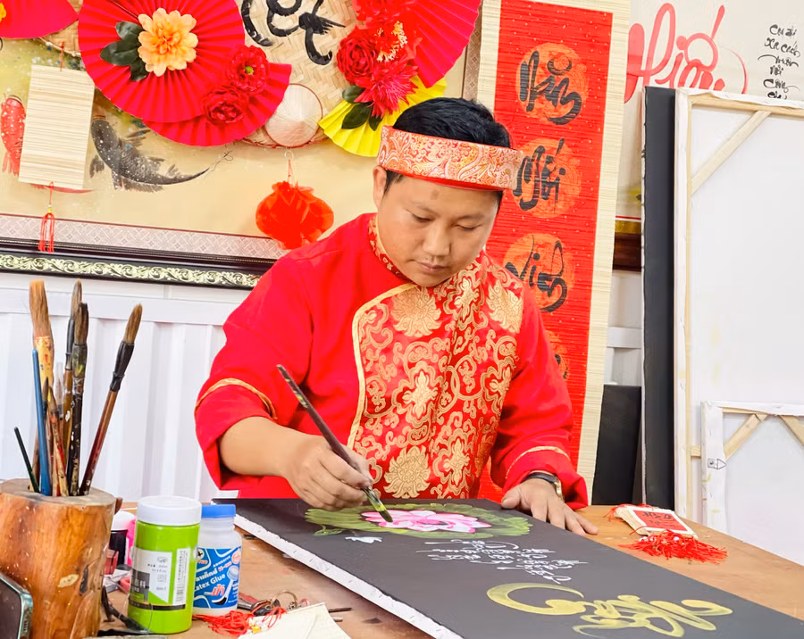 Anh Lê Trọng Hậu (Chủ nhiệm Câu lạc bộ Thư pháp Gia Lai) tất bật với công việc “cho chữ” đầu năm. Ảnh: Mai Ka