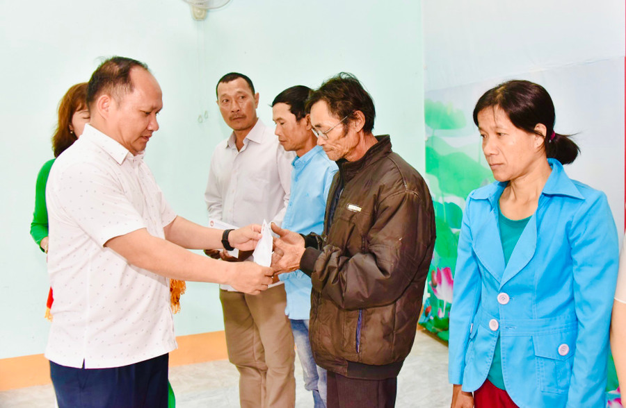 Phó Bí thư Tỉnh ủy Rah Lan Chung tặng quà cho các hộ nghèo thôn Tân Phong. Ảnh: Đức Thụy