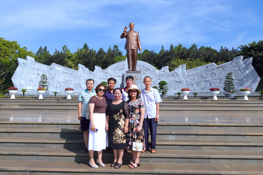 Bà Nguyễn Thị Nhàn (hàng trước, ở giữa; trú tổ 10, phường Yên Thế, TP. Pleiku) chụp ảnh lưu niệm cùng những người bạn trước Tượng đài Bác Hồ với các dân tộc Tây Nguyên. Ảnh: Mộc Trà