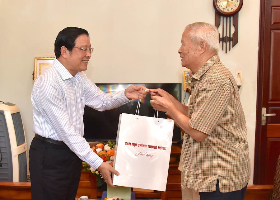 Thương binh Võ Nhỏ (bìa phải) đón nhận phần quà và cảm ơn sự quan tâm của Trưởng ban Nội chính Trung ương Phan Đình Trạc đến bản thân và gia đình. Ảnh: Đức Thụy