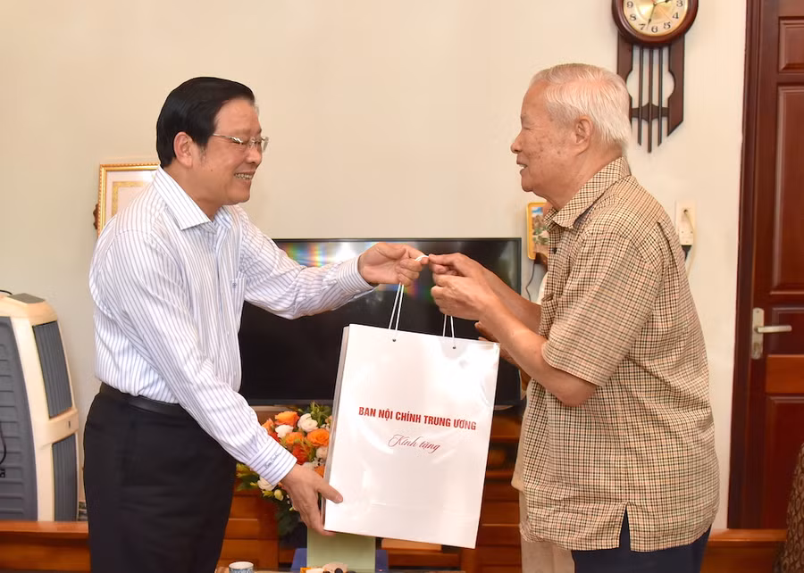 Thương binh Võ Nhỏ (bìa phải) đón nhận phần quà và cảm ơn sự quan tâm của Trưởng ban Nội chính Trung ương Phan Đình Trạc đến bản thân và gia đình. Ảnh: Đức Thụy