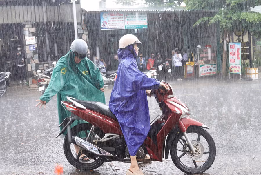 Nhiều phụ huynh tại TP. Pleiku đội mưa đón con sau khi kết thúc giờ thi môn Toán chiều 27-6. Ảnh: Mộc Trà