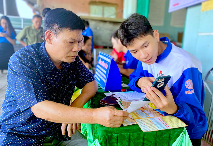 Đoàn viên, thanh niên phường Thống Nhất (TP. Pleiku) hướng dẫn người dân thực hiện DVCTT mức độ 3, 4 trên điện thoại thông minh. Ảnh: Mộc Trà