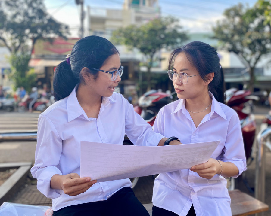 Thí sinh Y Thíu (bìa phải)-học viên Trung tâm Giáo dục thường xuyên tỉnh Gia Lai (điểm thi Trường THCS Nguyễn Du, TP. Pleiku) tự tin làm được trên 50% đề thi môn Toán. Ảnh: Mộc Trà