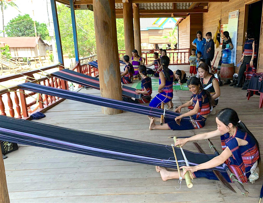 Phụ nữ Bahnar ở huyện Kông Chro học dệt thổ cẩm tại Nhà sinh hoạt cộng đồng. Ảnh: Mộc Trà