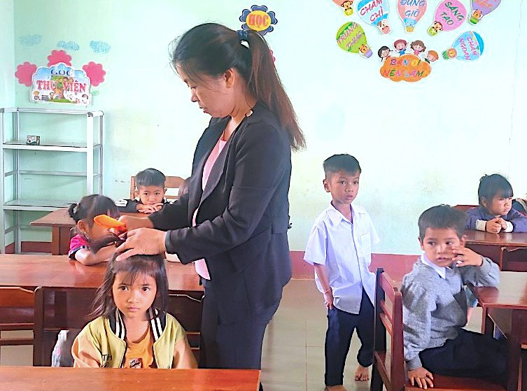 Học sinh Trường Phổ thông Dân tộc bán trú Tiểu học và THCS Đak Rong (huyện Kbang) được cô giáo chỉnh sửa quần áo, buộc tóc gọn gàng trong buổi tựu trường. Ảnh: Đàm Hà Học sinh Trường Phổ thông Dân tộc bán trú Tiểu học và THCS Đak Rong (huyện Kbang) được cô giáo chỉnh sửa quần áo, buộc tóc gọn gàng trong buổi tựu trường. Ảnh: Đàm Hà