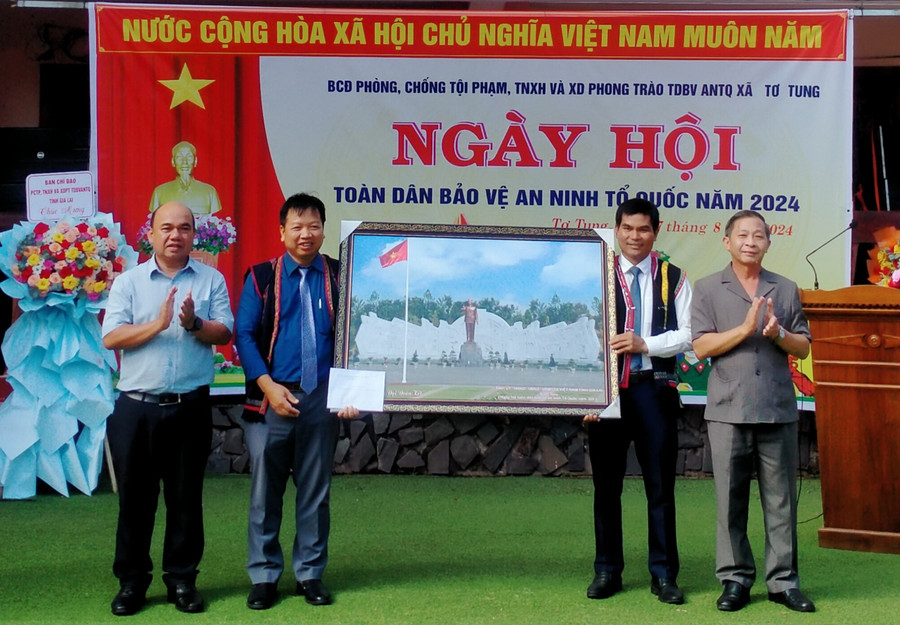 Trưởng ban Tuyên giáo Tỉnh ủy Huỳnh Thế Mạnh (bìa phải) và Phó Chủ tịch Ủy ban MTTQ Việt nam tỉnh Siu Trung (bìa trái) trao tặng phần quà của tỉnh cho xã Tơ Tung (huyện Kbang) tại Ngày hội Toàn dân bảo vệ ANTQ. Ảnh: H.H