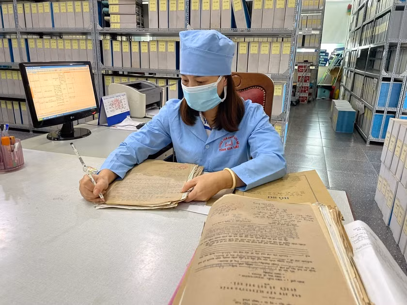 Viên chức Trung tâm Lưu trữ lịch sử tỉnh kiểm tra hồ sơ, chỉnh lý tài liệu. Ảnh: Lam Nguyên
