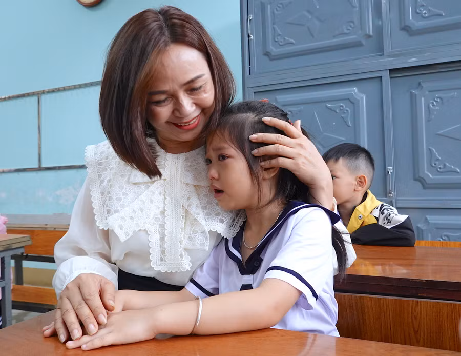 Cô Lê Thị Cẩm Nhi-giáo viên Trường Tiểu học Nguyễn Văn Trỗi (phường Hoa Lư, TP. Pleiku) ân cần dỗ dành học sinh còn bỡ ngỡ trong ngày đầu đến lớp. Ảnh: Mộc Trà